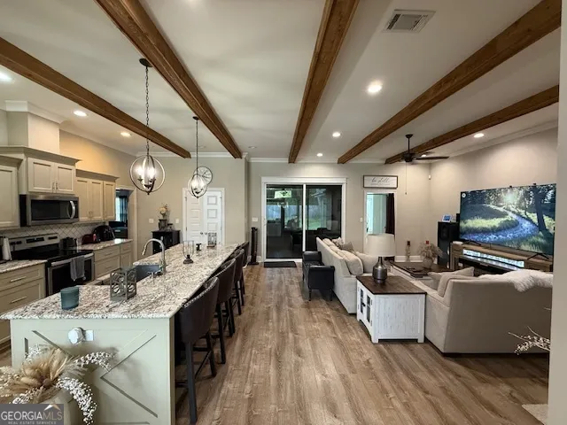 a large room with kitchen island stainless steel appliances lots of counter space and living room