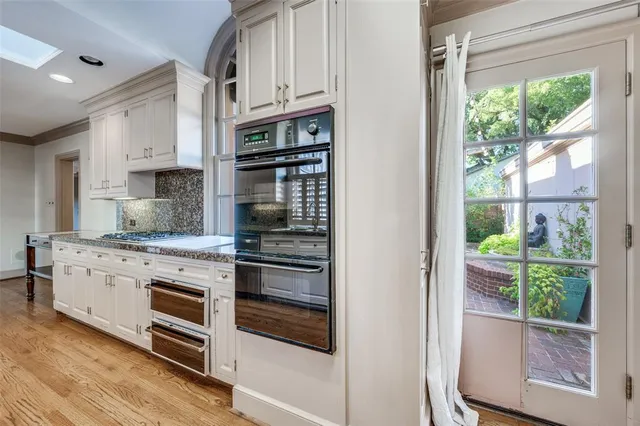 a kitchen with stainless steel appliances granite countertop a stove and white cabinets