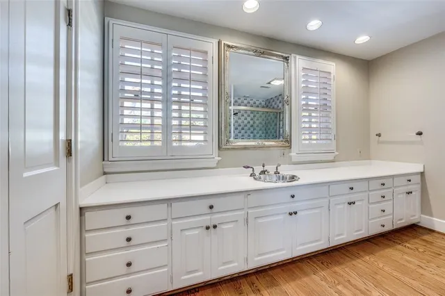 a bathroom with double vanity and a large mirror