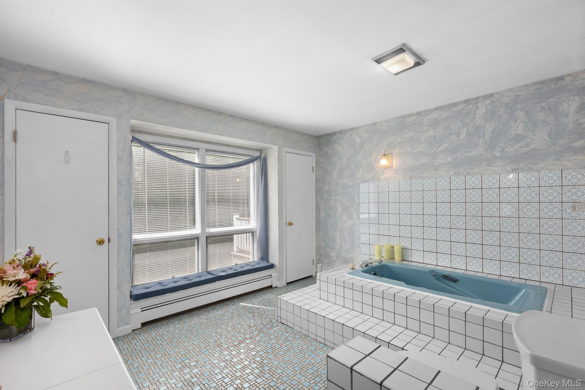 25 Harmony Road Brewster, NY 10509 - Photo 24 of 42 En-Suite bathroom with a clue spa tub, blue/white pattern floor tiles, vanity and closet.