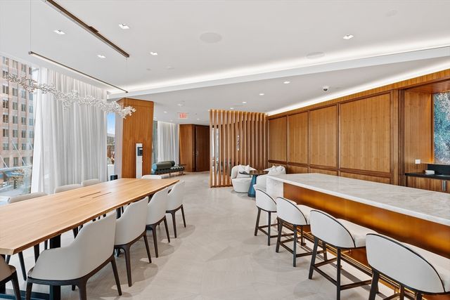 a dining room with furniture and a large window