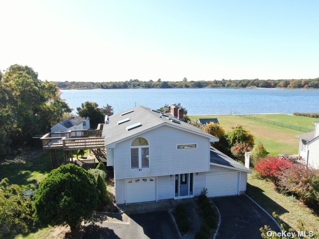 a aerial view of a house with outdoor space and lake view