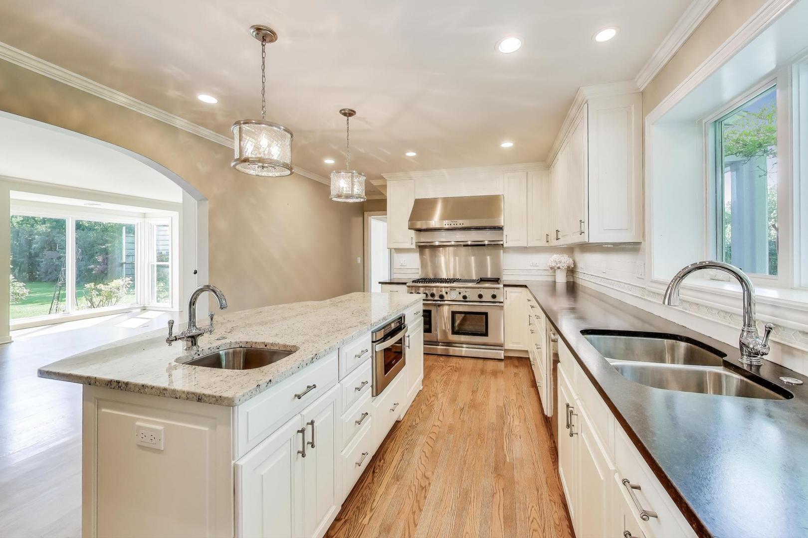 455 Sunset Ridge Road Northfield, IL 60093 - Photo 16 of 47 a kitchen with kitchen island granite countertop a sink a counter space appliances and cabinets