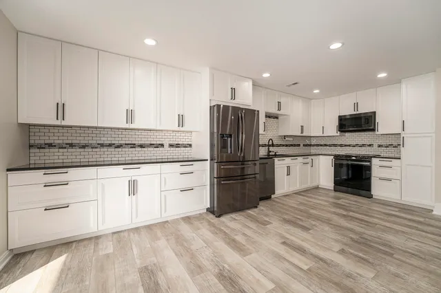 a kitchen with stainless steel appliances granite countertop a stove sink and refrigerator