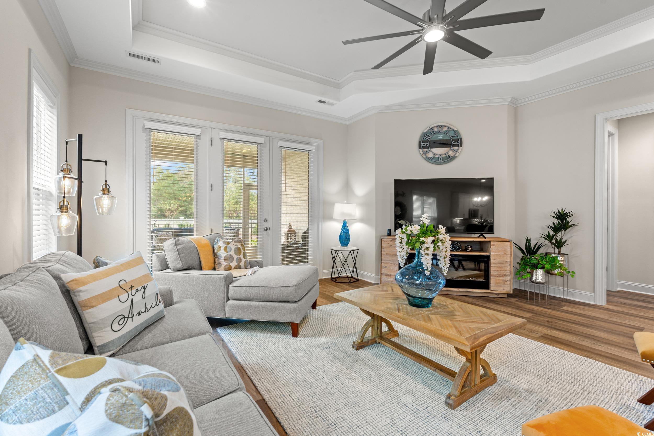 8338 Cape Dutch Loop Myrtle Beach, SC 29572 - Photo 12 of 39 Living room featuring ornamental molding, a tray ceiling, ceiling fan, wood finished floors, and french doors