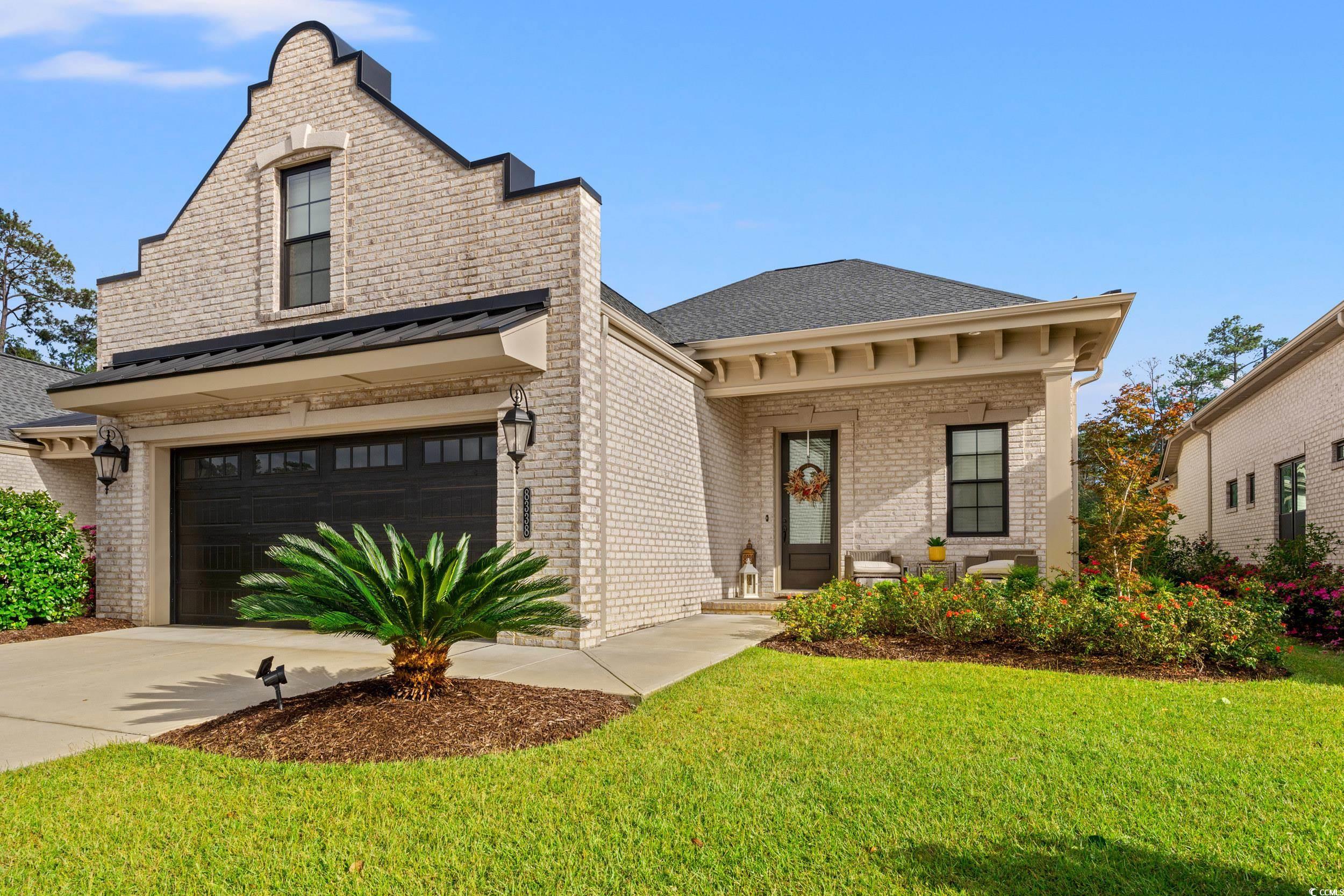 8338 Cape Dutch Loop Myrtle Beach, SC 29572 - Photo 31 of 39 View of front of house featuring brick siding, a standing seam roof, a front yard, and driveway