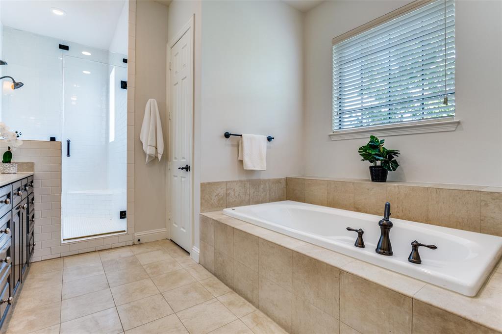 1120 Hemingway Lane Irving, TX 75063 - Photo 17 of 24 a bathroom with a tub a sink a mirror and a shower