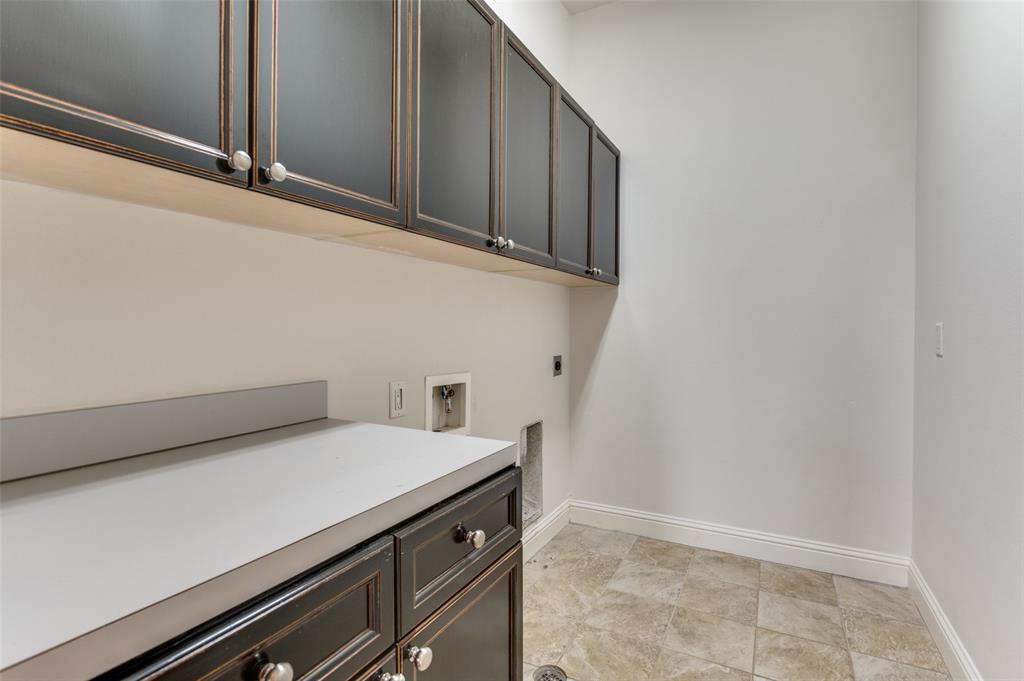 1120 Hemingway Lane Irving, TX 75063 - Photo 21 of 25 Laundry room featuring lots of built in cabinets.