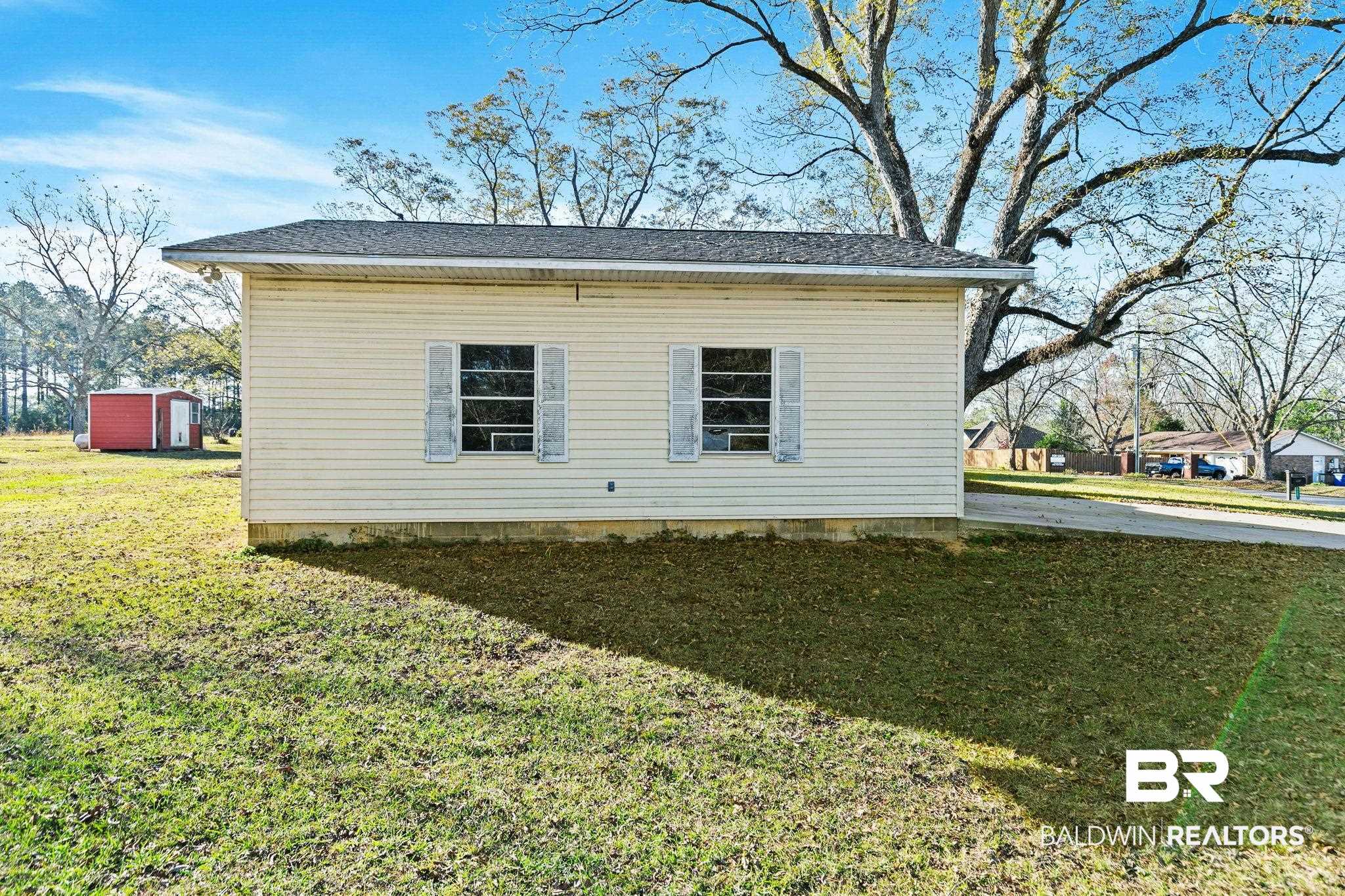 21267 Loop Road Andalusia, AL 36421 - Photo 54 of 72 View of side of property featuring a lawn, a shingled roof, and a storage shed