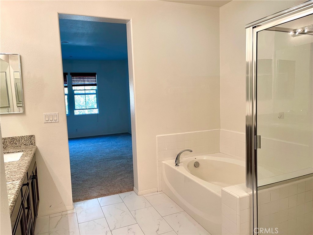 312 Quail Ridge Irvine, CA 92603 - Photo 16 of 35 a bathroom with a bathtub and a shower