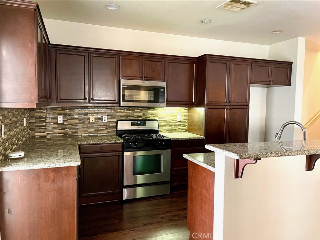 312 Quail Ridge Irvine, CA 92603 - Photo 4 of 35 a kitchen with stainless steel appliances granite countertop a sink stove and refrigerator