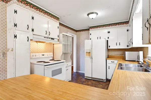 a kitchen with stainless steel appliances a stove refrigerator sink and wooden floor