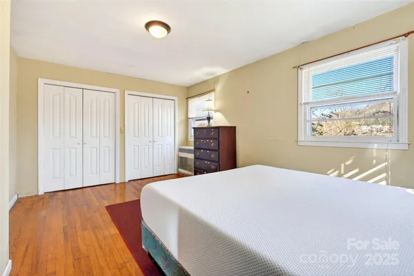 a spacious bedroom with a bed and a dresser