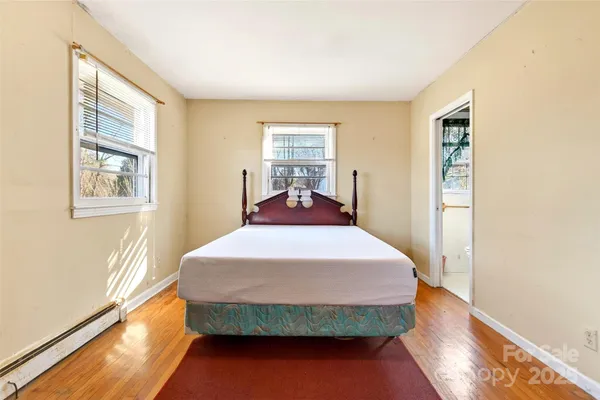 a bedroom with a bed and wooden floor