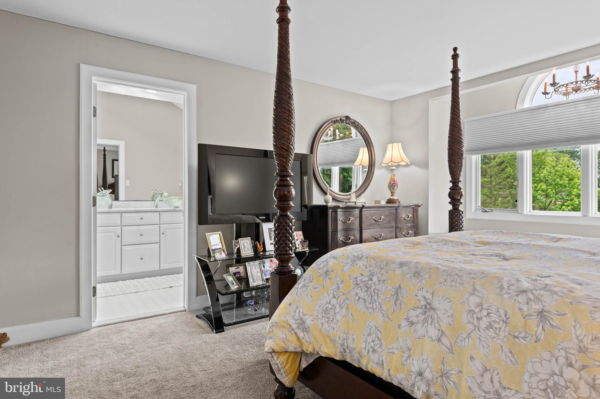 24 Greythorne Woods Circle Wayne, PA 19087 - Photo 20 of 29 a bedroom with a bed a mirror on the dresser and a large window