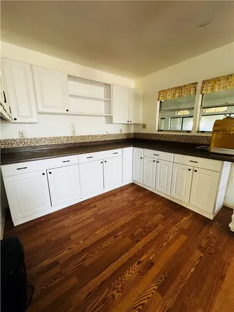 a kitchen with stainless steel appliances granite countertop a sink cabinets and wooden floor