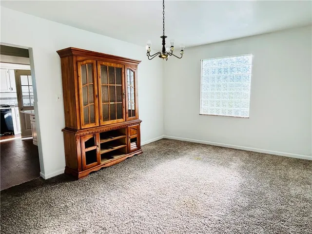a view of an empty room with window and furniture