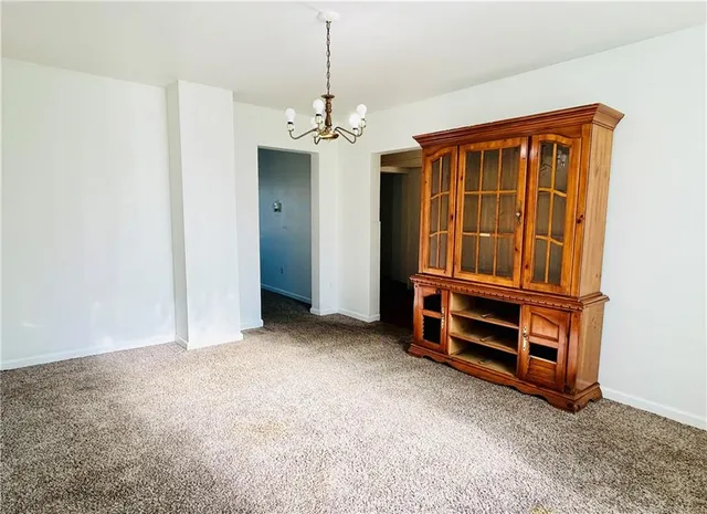 an empty room with a fireplace cabinet and stairs