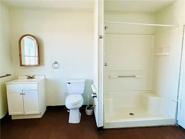 a bathroom with a granite countertop sink toilet and shower