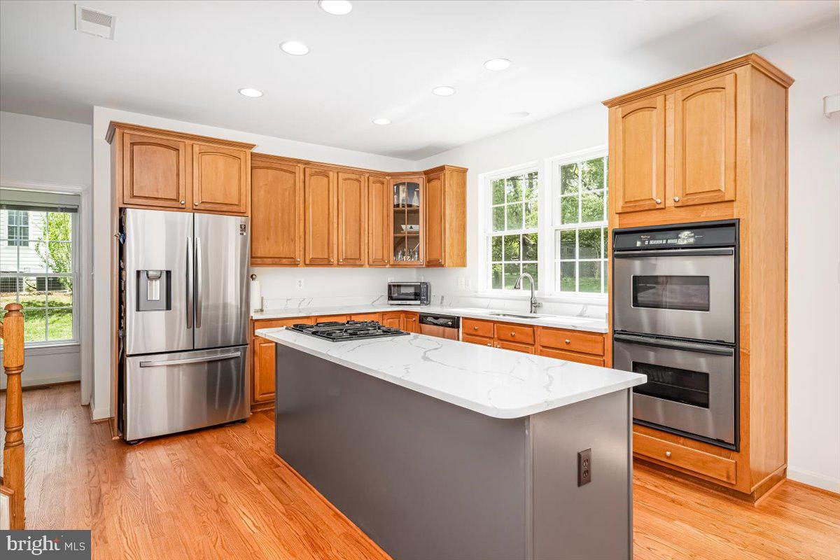 15205 Lions Den Road Burtonsville, MD 20866 - Photo 12 of 31 a kitchen with granite countertop a refrigerator and a stove top oven