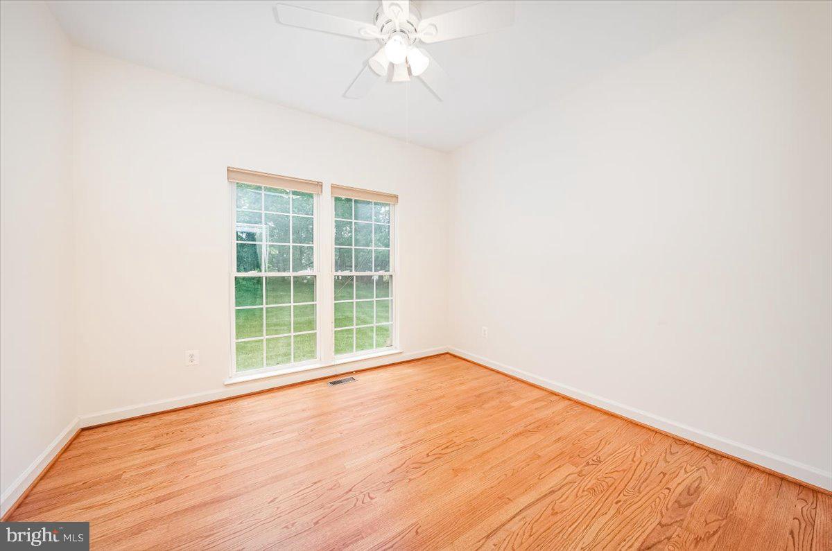 15205 Lions Den Road Burtonsville, MD 20866 - Photo 23 of 31 an empty room with wooden floor and windows