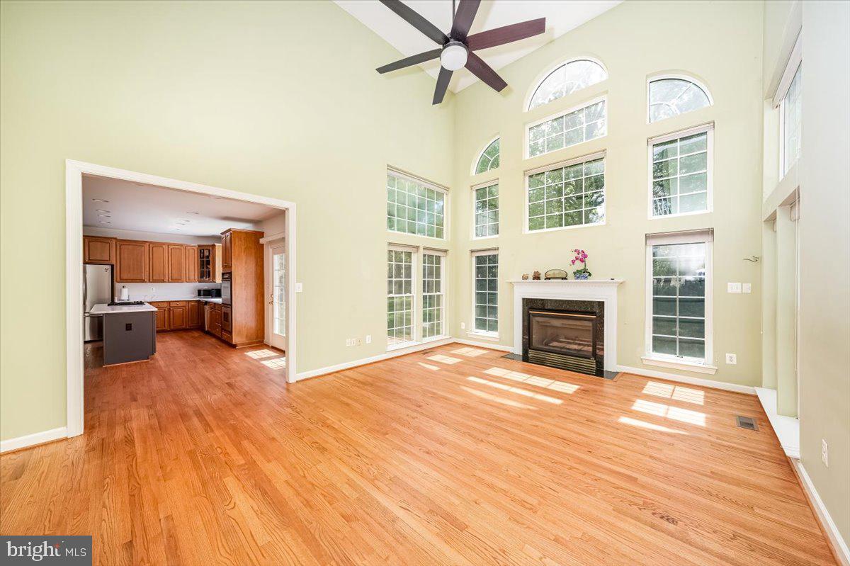 15205 Lions Den Road Burtonsville, MD 20866 - Photo 8 of 31 a view of a livingroom with a fireplace a ceiling fan and wooden floor