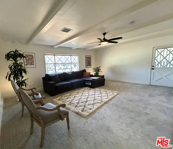 a living room with furniture a chandelier and a rug