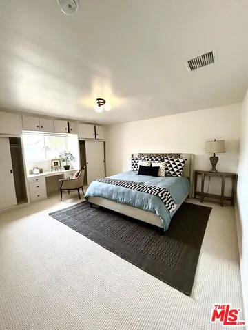 a spacious bedroom with a bed and couch
