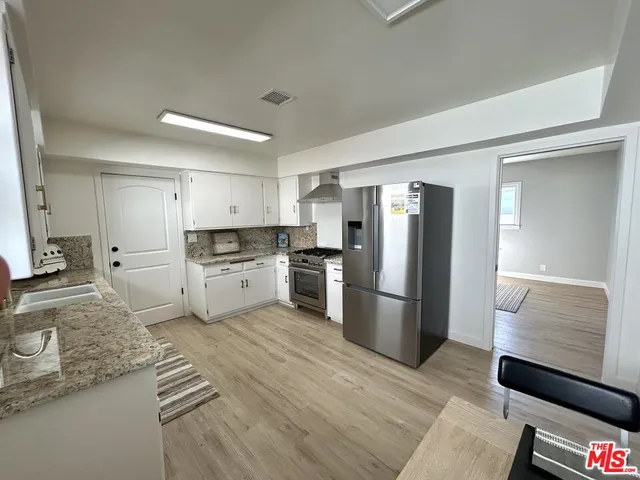 a kitchen with stainless steel appliances granite countertop a refrigerator and a stove