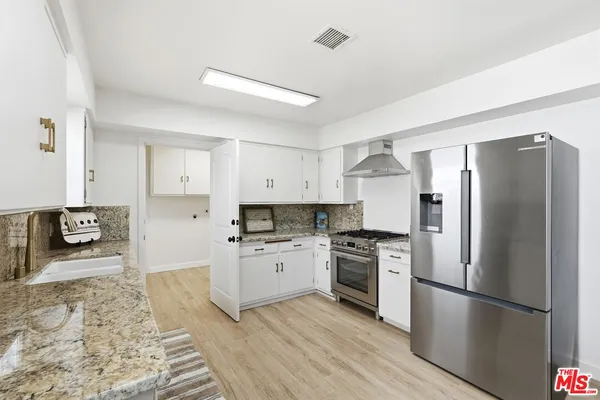 a kitchen with stainless steel appliances granite countertop a refrigerator stove a sink and dishwasher