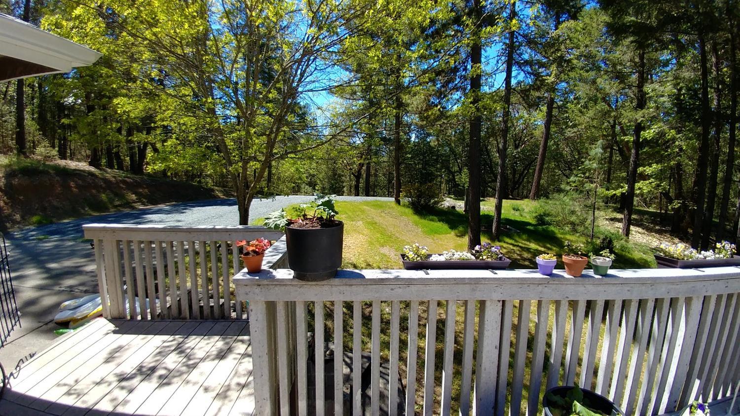 1390 Crow Road Merlin, OR 97532 - Photo 8 of 35 a view of a deck with a table and chairs under an umbrella with wooden fence