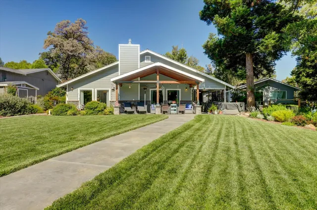 an aerial view of a house with a yard and a large tree