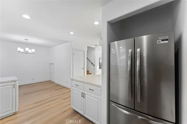 a view of a kitchen with refrigerator and wooden floor