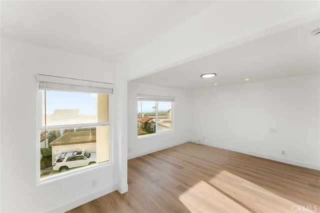an empty room with wooden floor and window