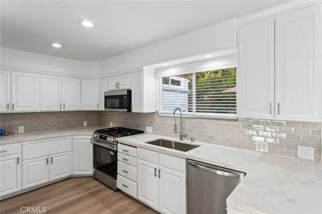 a kitchen with a sink stove top oven and cabinets