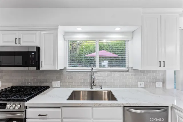 a kitchen with a sink a stove and cabinets