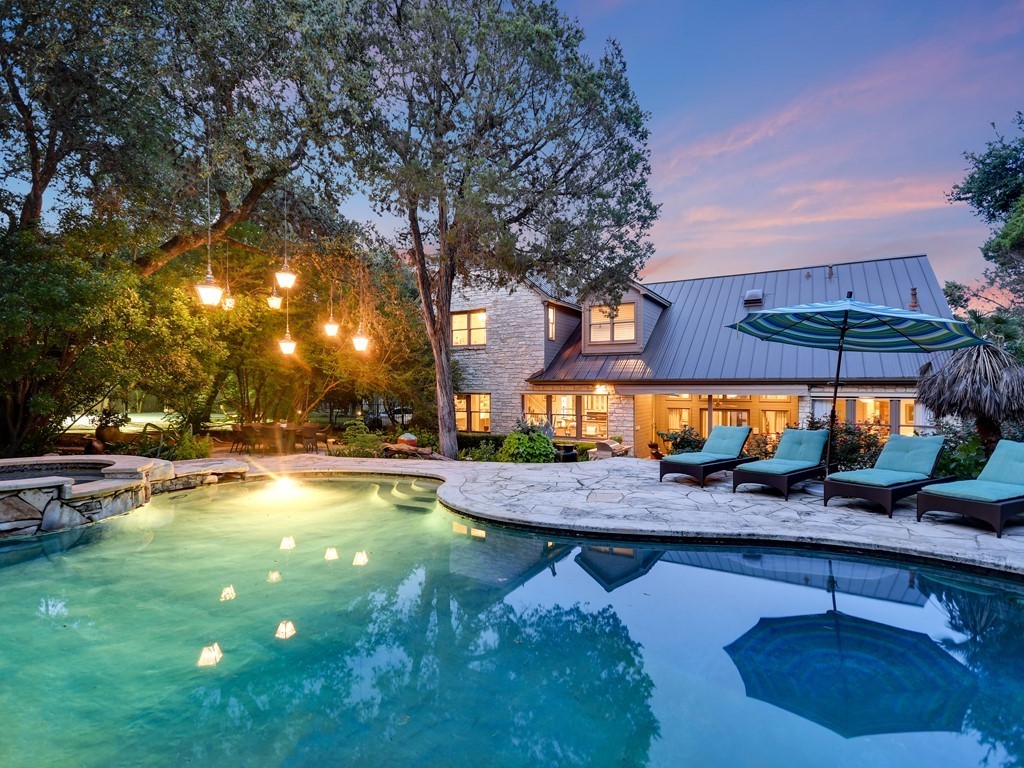 3704 Woodcutters Way Austin, TX 78746 - Photo 1 of 1 a view of a swimming pool with tables and chairs under an umbrella