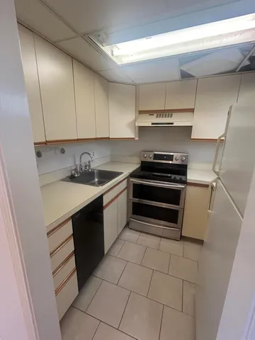 a kitchen with a sink a stove and cabinets