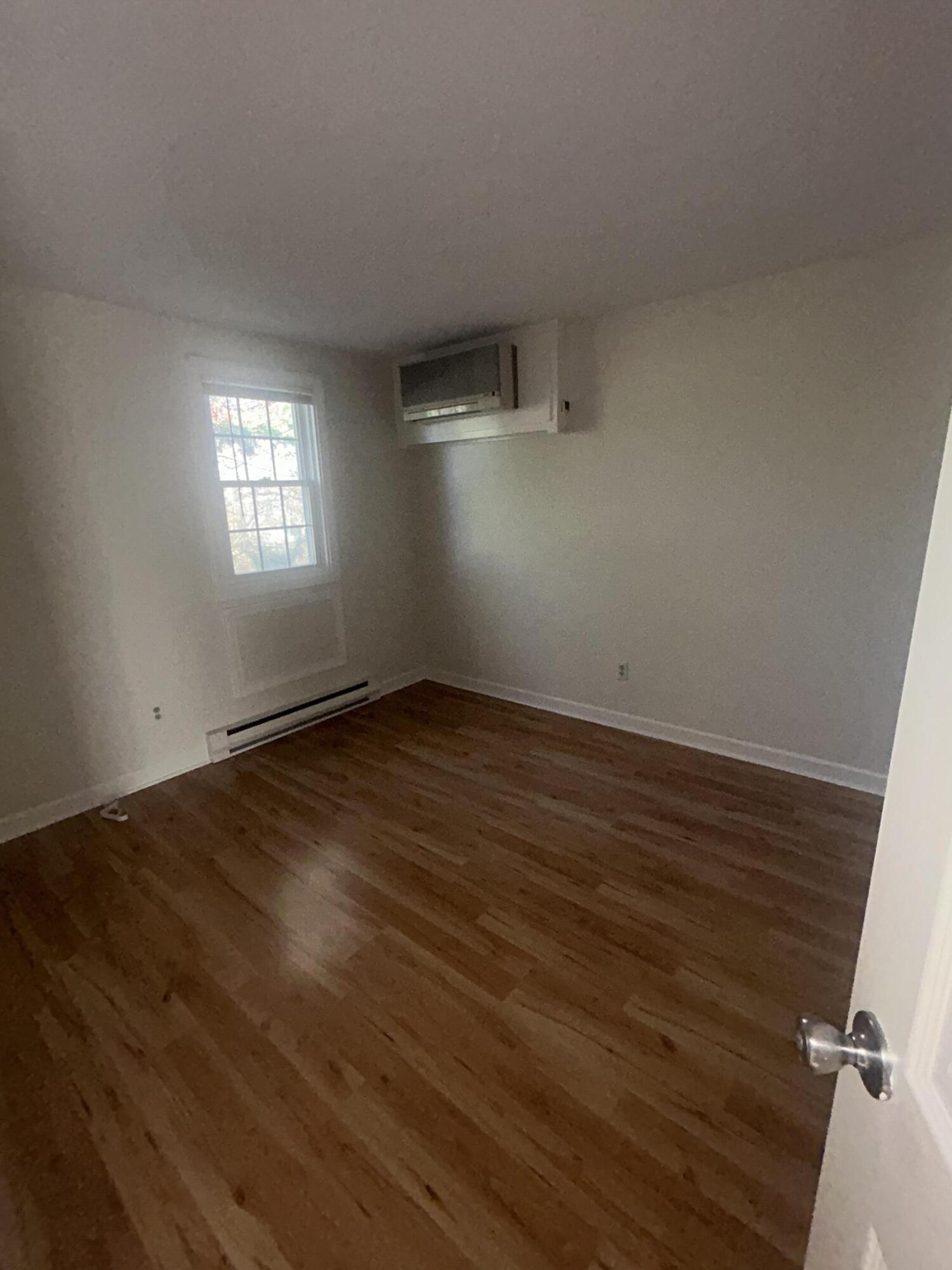 135 West Main Street, Unit 41 Hyannis, MA 02601 - Photo 8 of 9 an empty room with wooden floor and windows