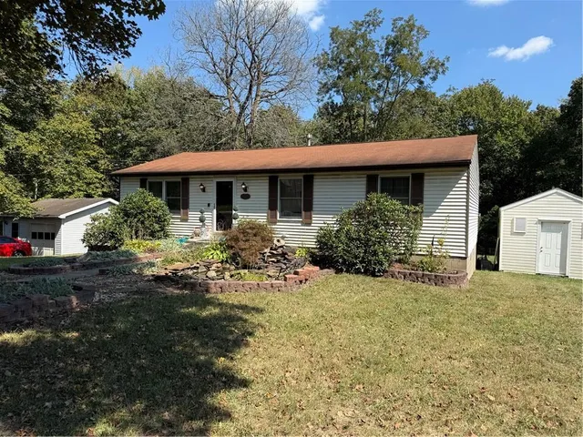 a front view of a house with yard and green space