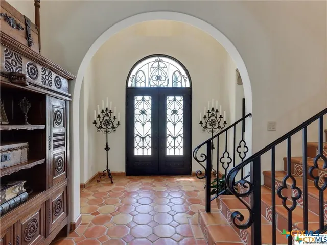 a dining room with wooden floor a chandelier a wooden table and chairs