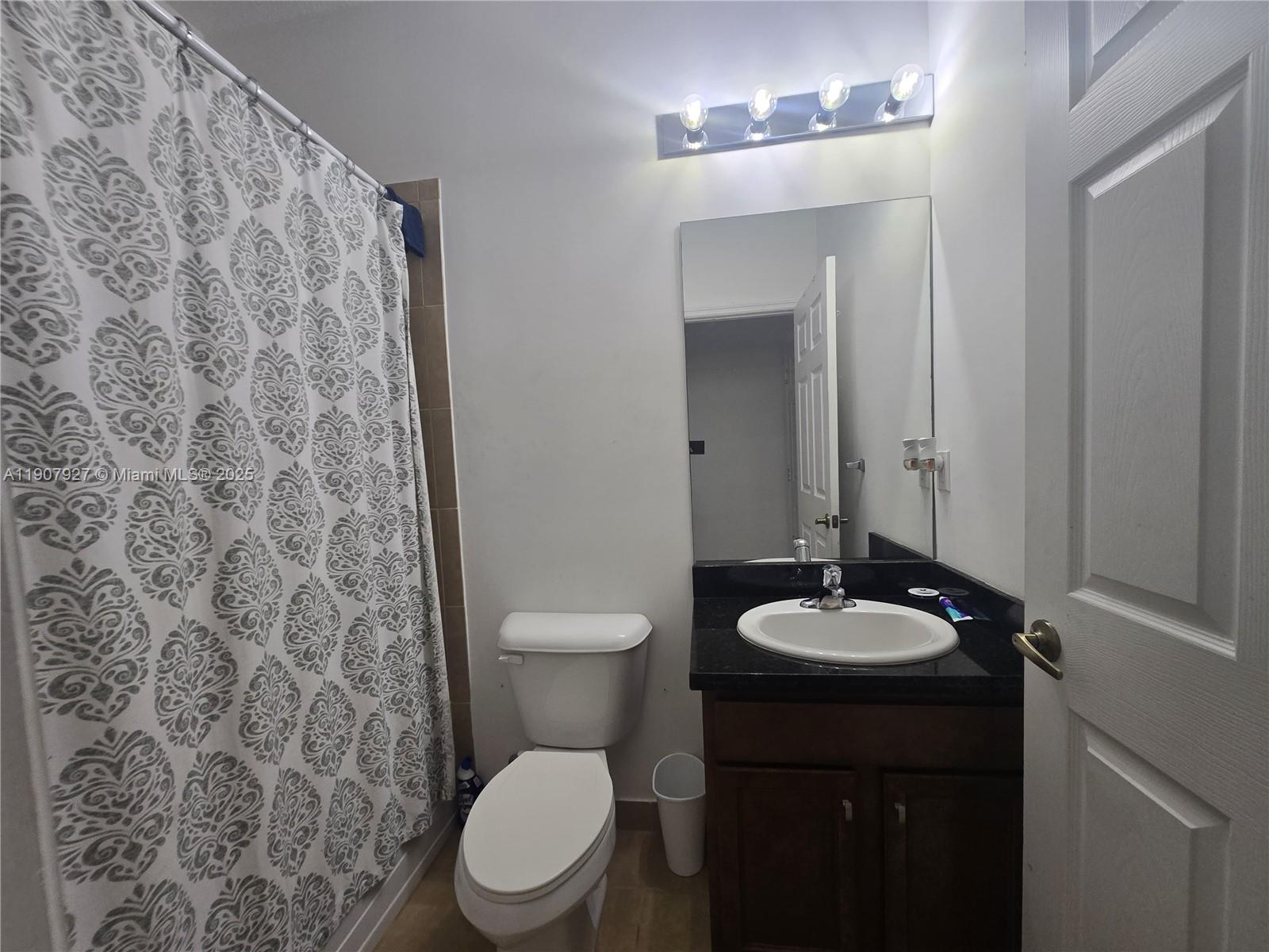 11938 Southwest 26th Court Miramar, FL 33025 - Photo 17 of 61 a bathroom with a granite countertop toilet and a sink