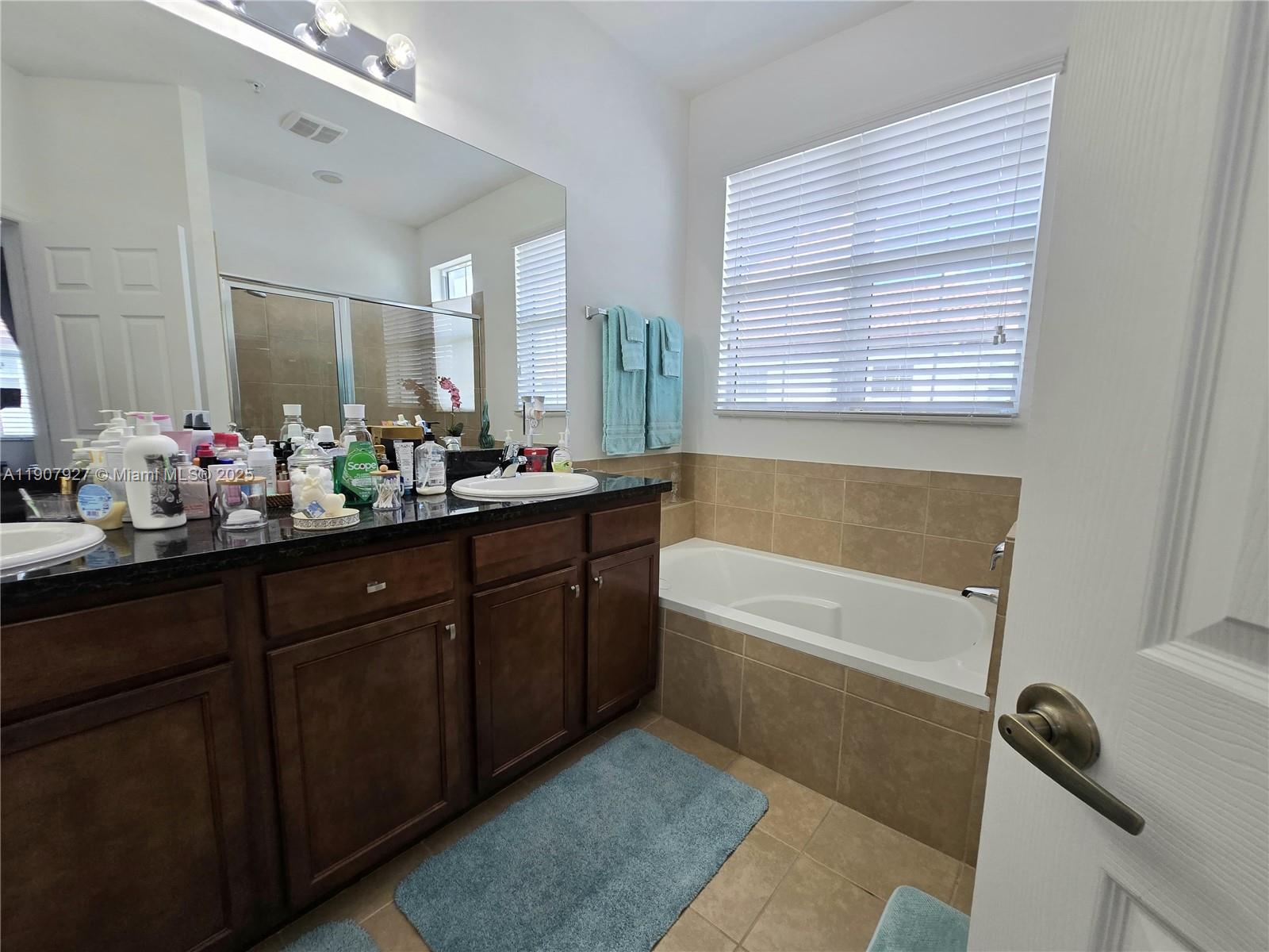 11938 Southwest 26th Court Miramar, FL 33025 - Photo 40 of 61 a bathroom with a tub sink and mirror