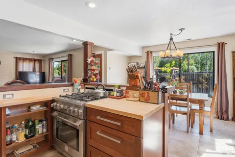 a kitchen with a stove a sink and a dining table