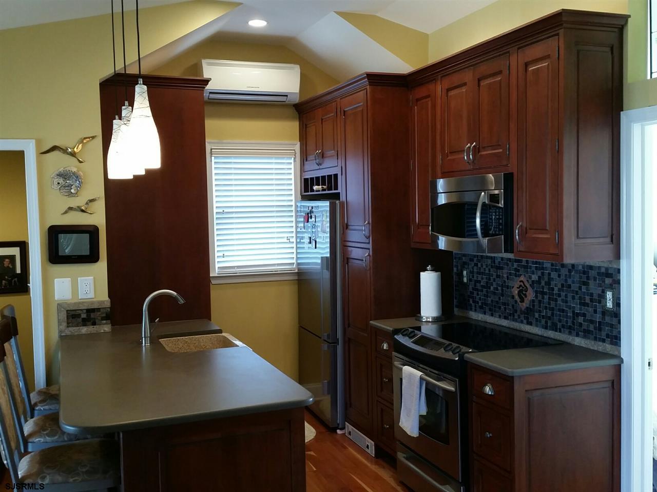 9 Wesley Road Ocean City, NJ 08226 - Photo 20 of 25 a kitchen with stainless steel appliances granite countertop a stove a refrigerator and a microwave
