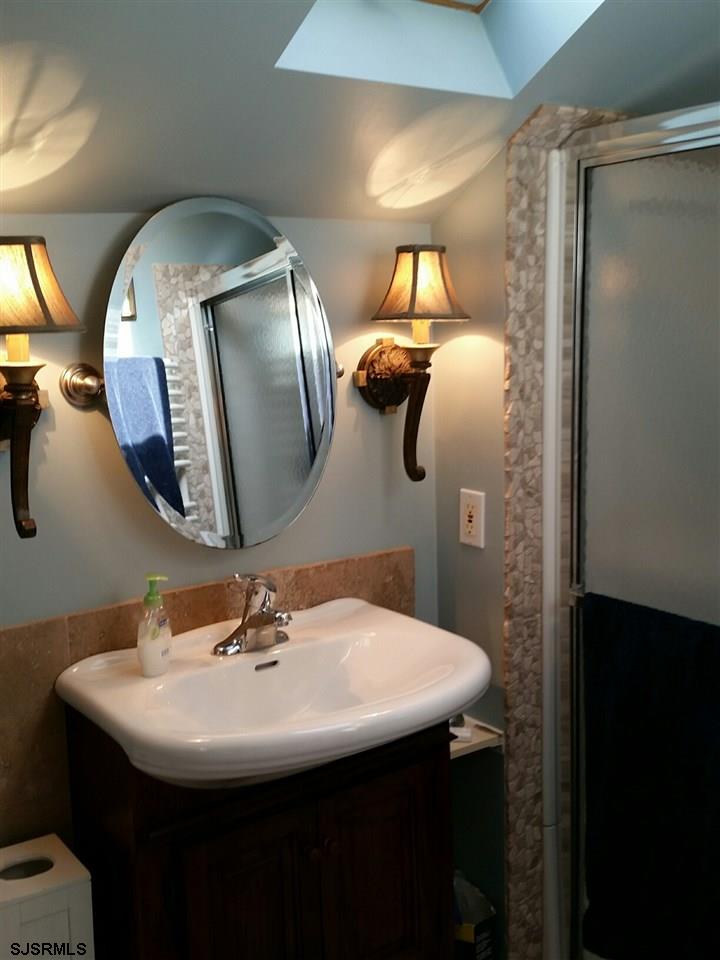 9 Wesley Road Ocean City, NJ 08226 - Photo 21 of 25 a bathroom with a sink and mirror