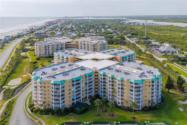 a large building with a view of a big yard and lake view