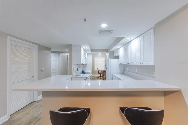 a kitchen with kitchen island stainless steel appliances a sink and a refrigerator