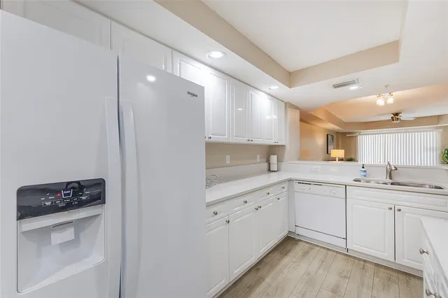 a kitchen with a sink cabinets and wooden floor