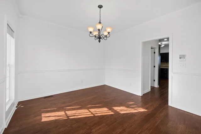 a view of a chandelier in an empty room with wooden floor